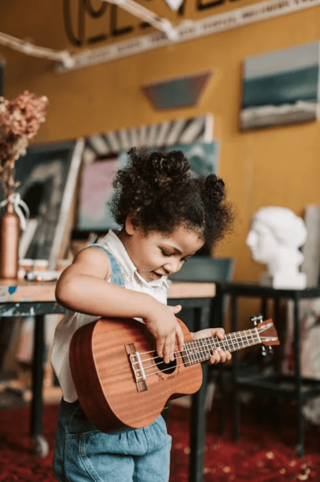 Girl playing a ukulele in an art studio