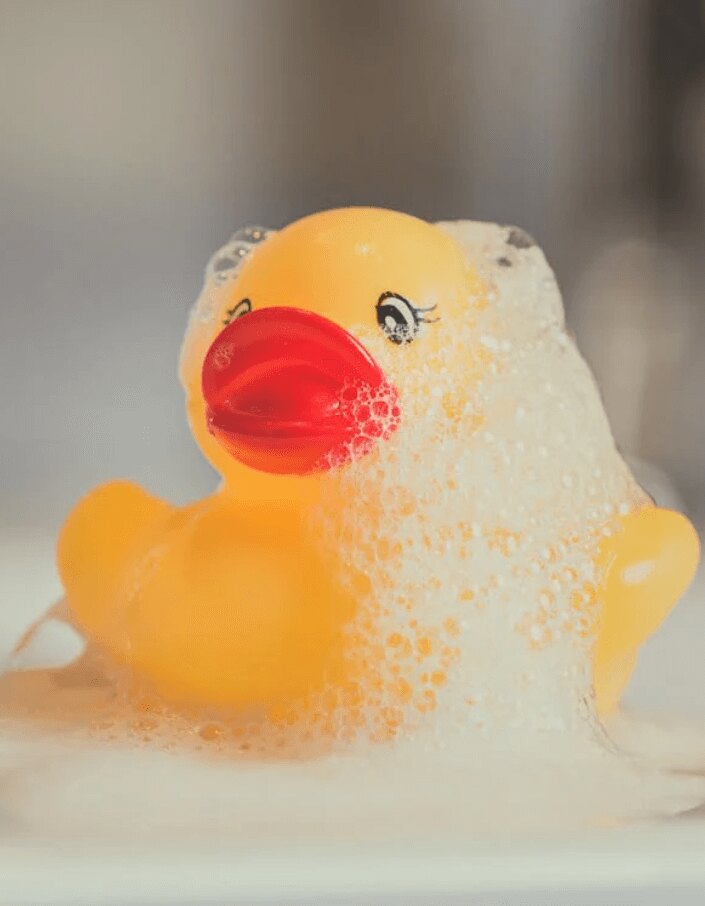 A rubber duck covered in bath bubbles