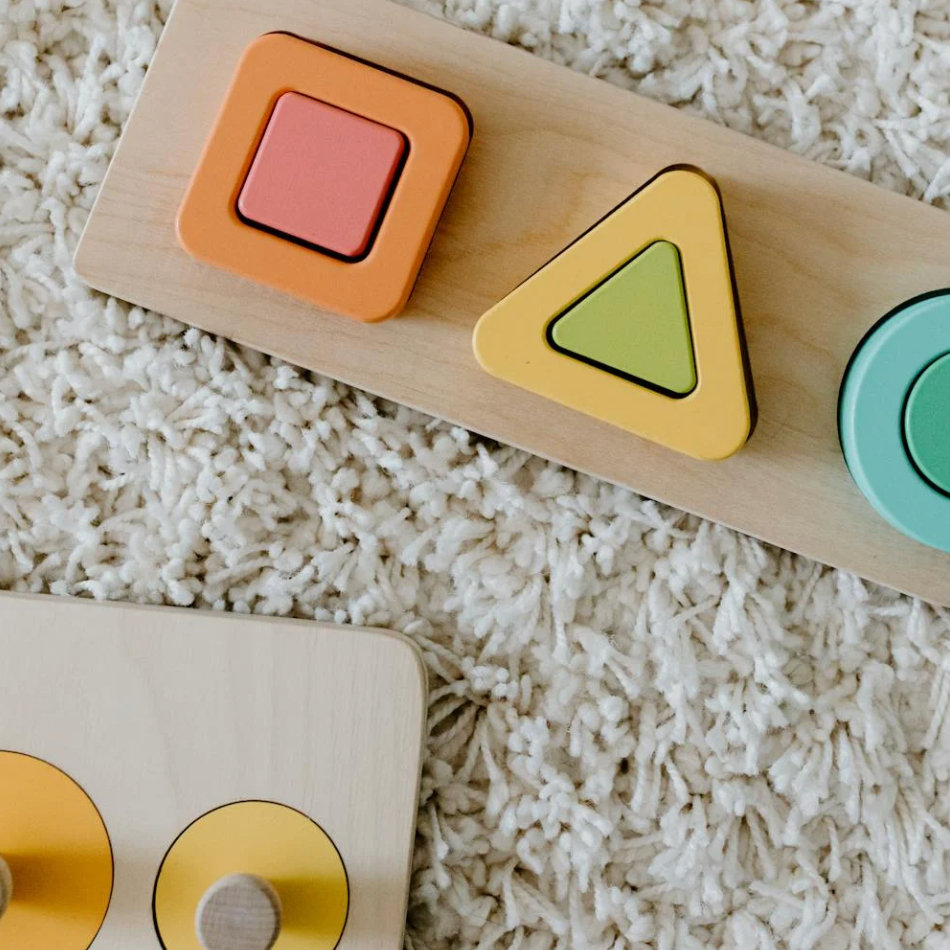 Wooden shape-sorter puzzles on a fluffy rug